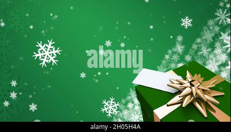 Immagine di fiocchi di neve cadenti sopra regalo di natale Foto Stock