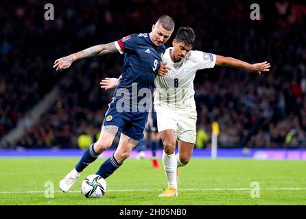 I Lyndon Dykes scozzesi (a sinistra) e il Dor Peretz d'Israele combattono per la palla durante la partita di qualificazione della Coppa del mondo FIFA ad Hampden Park, Glasgow. Data foto: Sabato 9 ottobre 2021. Foto Stock