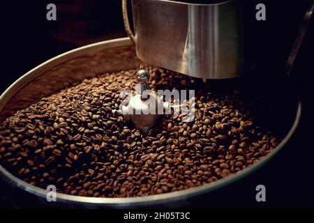 Processo di miscelazione durante la tostatura del caffè nella macchina Foto Stock