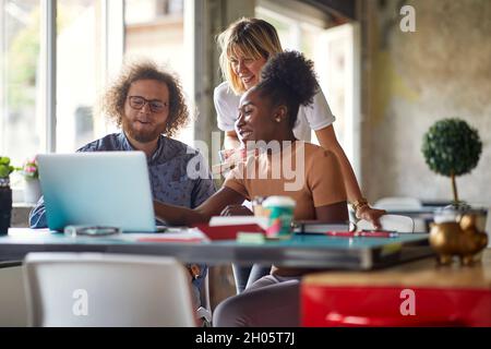 Gruppo di giovani impiegati che chiacchierano insieme all'ufficio Foto Stock