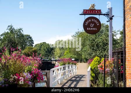 Newbury, Berkshire, Inghilterra, Regno Unito. 2021. Cartello da pub e passerella con esposizione floreale lungo il canale Kennett e Avon a Newbury, Regno Unito. Foto Stock