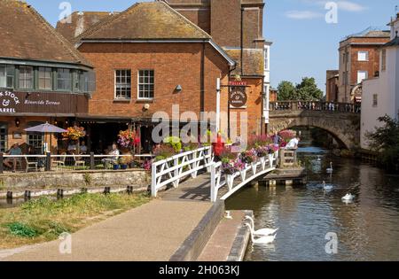 Newbury, Berkshire, Inghilterra, Regno Unito. 2021. Paesaggio verso il ponte della città vecchia e un pub con esposizione floreale lungo il canale Kennett e Avon Foto Stock