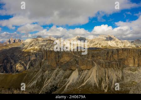 Vista aerea del Brunecker Turm, Sassolungo montagna e passo passo Gardena durante il tramonto. Dolomiti in Alto Adige Foto Stock