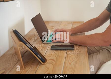 Primo piano delle mani di un uomo che digita su una tastiera, cercando informazioni. Un copywriter freelance sta lavorando ad un progetto. Il concetto di lavoro a distanza. Foto di alta qualità Foto Stock