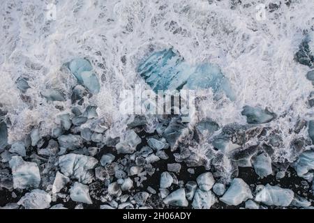 Vista aerea del ghiaccio e floes iceberg sulla spiaggia di diamante durante il tramonto. L'inizio della primavera in Islanda Foto Stock