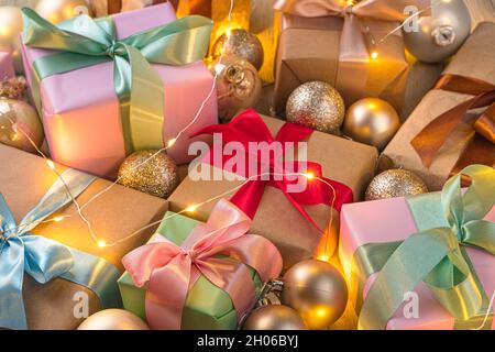 Sfondo di Natale con regali e palle di Natale alla luce di una ghirlanda. Vista laterale, primo piano. Foto Stock
