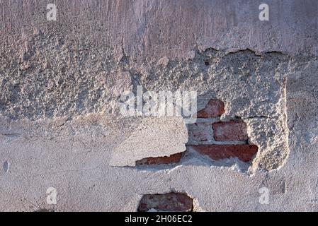 Vecchio muro di mattoni intonacati, invecchiato e stagionato, astratto texture sfondo Foto Stock