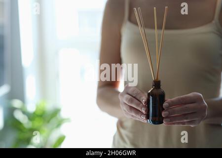 Bottiglia con bastoncini d'incenso in primo piano femminile Foto Stock