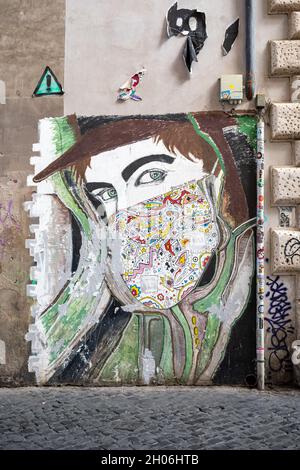 Street art. Grande murale dell'attore Damiano de Andre con maschera facciale colorata nel quartiere Trastevere di Roma. Foto Stock