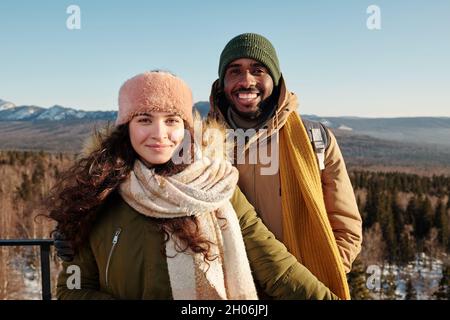 Felice giovane coppia interculturale godendo giorno d'inverno in ambiente naturale Foto Stock