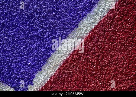 Sfondo minimalista testurizzato con pareti dipinte a spruzzo come arte graffiti, realizzato con vivaci colori viola scuro e rosso Foto Stock