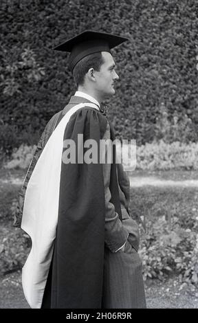 Anni '50, storico, un giovane inglese con un baffo corto e indossando un abito a doppia prora e una cravatta ad arco in posa per la sua foto in un abito da laurea e cappellino accademico quadrato, spesso definito come cappellino e abito, Inghilterra, Regno Unito. Indossato con regalia accademica alle cerimonie di laurea, il suo tipo speciale di cappellino è noto come un mortarboard o a volte come cappellino Oxford e consiste di una tavola quadrata orizzontale fissata su un cappellino cranio con un tasello attaccato al centro. Il suo aspetto distintivo significa che la PAC è associata al mondo accademico. Foto Stock