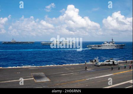 Philippine Sea, Stati Uniti. 03 Ottobre 2021. Il portaerei USS Ronald Reagan della Marina statunitense di classe Nimitz, a sinistra, veleggia in formazione accanto al portaerei HMS Queen Elizabeth della Marina reale britannica, centro, e al cacciatorpediniere giapponese di classe Hyuga JS ISE mentre transitano accanto al portaerei di classe Nimitz USS Carl Vinson 3 ottobre 2021 nel Mare delle Filippine. Credit: MC3 Erin C. Zorich/U.S. Navy/Alamy Live News Foto Stock