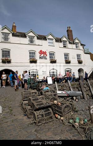 Il Red Lion Hotel si affaccia sul porto di Clovelly con barche ormeggiate sulla spiaggia a bassa marea nel Devon Nord Foto Stock