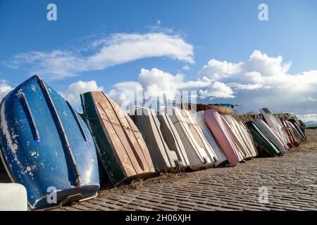 Barche a remi appoggiate contro una parete del porto a Dysart, Fife, Scozia Foto Stock