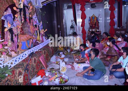 Devoti seduti di fronte al coperto Durga Idol volto come il Pooja non è ancora completo per svelarlo. Devi Bodhon Pooja è condotta e il volto di D. Foto Stock