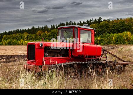trattore cingolato in posizione eretta in un campo su terreni arabili Foto Stock
