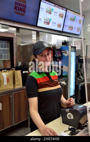 Giovane e attraente staff femminile che lavora nel fast food Burger King, UK Foto Stock