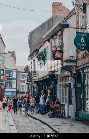 York, UK - 22 giugno 2021: Fila di negozi sul Shambles, una vecchia strada a York, Inghilterra, con sovrastanti edifici a graticcio, alcuni risalenti al passato Foto Stock