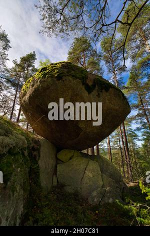 Una roccia enorme si sta equilibrando su un'altra roccia al naturreservat Herbergshult a smaland, in svezia. Foto Stock