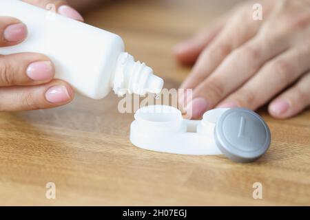 La donna gocciola la soluzione della lente nel primo piano della scatola Foto Stock