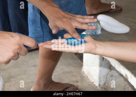 Mani dei bambini latini che dipingono e bevono acqua, celebrazione educativa. Foto Stock