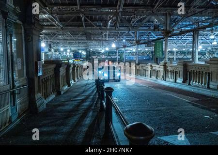 Edimburgo, stazione ferroviaria di Waverley, Scozia, Regno Unito, 11 ottobre 2021: Il re della Malesia (Abdullah di Pahang) (indossando un cappello, occhiali e una copertura blu) circondato dal suo entourage e team di sicurezza, arriva alla stazione ferroviaria di Waverley a Edimburgo. Una flotta di mini bus in attesa, per prendere il re e il suo entourage off. La British Transport Police ha fornito anche una maggiore sicurezza. Credit Barry Nixon/Alamy Live News Foto Stock