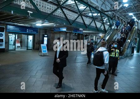 Edimburgo, stazione ferroviaria di Waverley, Scozia, Regno Unito, 11 ottobre 2021: Il re della Malesia (Abdullah di Pahang) (indossando un cappello, occhiali e una copertura blu) circondato dal suo entourage e team di sicurezza, arriva alla stazione ferroviaria di Waverley a Edimburgo. Una flotta di mini bus in attesa, per prendere il re e il suo entourage off. La British Transport Police ha fornito anche una maggiore sicurezza. Credit Barry Nixon/Alamy Live News Foto Stock