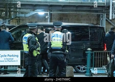 Edimburgo, stazione ferroviaria di Waverley, Scozia, Regno Unito, 11 ottobre 2021: Il re della Malesia (Abdullah di Pahang) (indossando un cappello, occhiali e una copertura blu) circondato dal suo entourage e team di sicurezza, arriva alla stazione ferroviaria di Waverley a Edimburgo. Una flotta di mini bus in attesa, per prendere il re e il suo entourage off. La British Transport Police ha fornito anche una maggiore sicurezza. Credit Barry Nixon/Alamy Live News Foto Stock