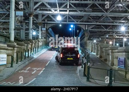 Edimburgo, stazione ferroviaria di Waverley, Scozia, Regno Unito, 11 ottobre 2021: Il re della Malesia (Abdullah di Pahang) (indossando un cappello, occhiali e una copertura blu) circondato dal suo entourage e team di sicurezza, arriva alla stazione ferroviaria di Waverley a Edimburgo. Una flotta di mini bus in attesa, per prendere il re e il suo entourage off. La British Transport Police ha fornito anche una maggiore sicurezza. Credit Barry Nixon/Alamy Live News Foto Stock