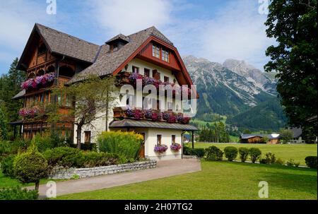 Casa rustica con gerani sul davanzale nella regione di Schladming-Dachstein in Austria Foto Stock