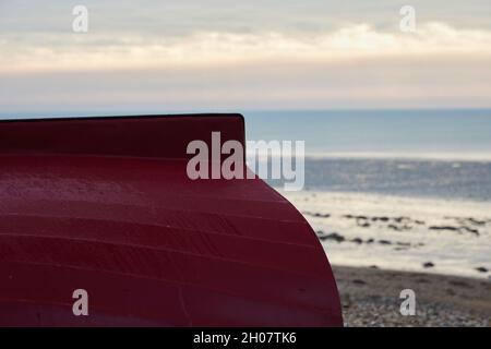 Vista esterna di una parte di un piccolo stivale capovolto sulla spiaggia. Foto Stock