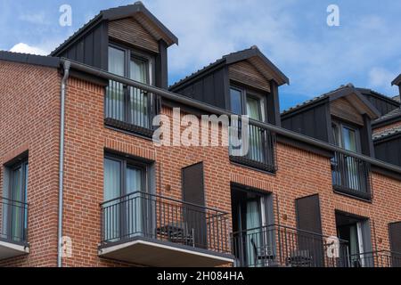Facciata in mattoni di un edificio a più piani con splendidi balconi. Foto Stock