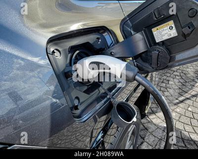 Auto elettrica mentre si ricarica la batteria alla centrale elettrica,nuova tecnologia automobilistica Foto Stock