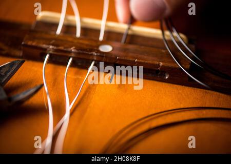 Concetto di chitarra classica Restring. Primo piano alle nuove corde. Foto Stock