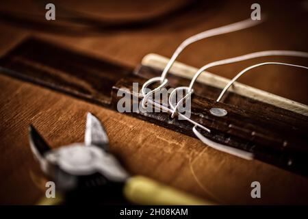 Concetto di chitarra classica Restring. Primo piano alle nuove corde. Foto Stock