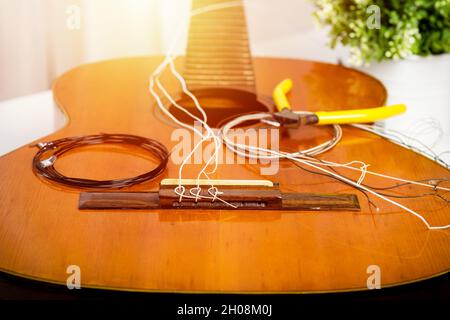 Concetto di chitarra classica Restring. Primo piano alle nuove corde. Foto Stock