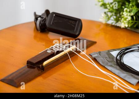 Concetto di chitarra classica Restring. Primo piano alle nuove corde. Foto Stock