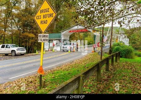 Dingmans Ferry, PA, USA - 10 ottobre 2021: Un'auto si ferma per pagare un pedaggio al Ponte di Dingman in Pennsylvania. Il ponte è un ponte a pedaggio di proprietà privata Foto Stock