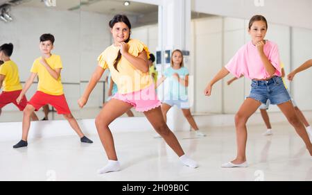 I bambini che esercitano la danza moderna si muovono insieme Foto Stock