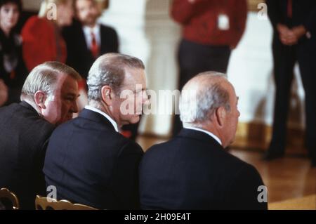 Da sinistra a destra: Procuratore generale degli Stati Uniti Edwin Meese; Segretario del Tesoro degli Stati Uniti James A. Baker, III; E il Segretario di Stato americano George P. Shultz siediti insieme nella stanza Est della Casa Bianca a Washington, DC mentre attendono l'inizio della cerimonia di giuramento per la Giustizia associata della Corte Suprema Anthony M. Kennedy il 18 febbraio 1988.Credit: Arnie Sachs / CNP / MediaPunch Foto Stock