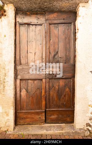 Vista frontale di una massiccia porta in legno ornato Foto Stock