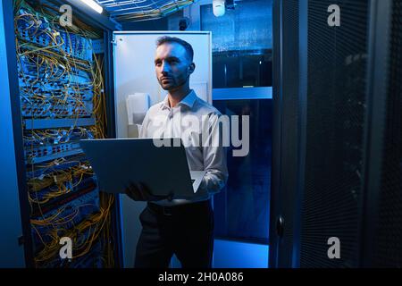 Amministratore del server che esegue la manutenzione della rete nel data center Foto Stock