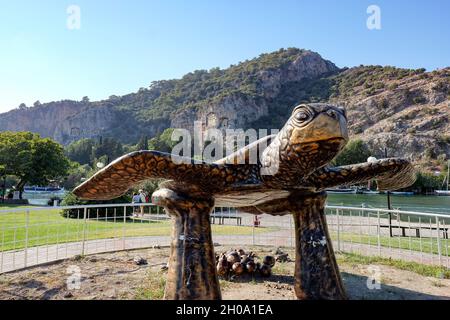 Dalyan, Turchia. 27 settembre 2021. Una scultura di una tartaruga a testa di loggerhead è situata sul lungomare della città resort sul canale di Dalyan nella Turchia sud-occidentale. Questo è il terreno di deposizione delle tartarughe Caretta caretta. La spiaggia di Iztuzu è rigorosamente monitorata per proteggere le tartarughe. Credit: Jens Kalaene/dpa-Zentralbild/ZB/dpa/Alamy Live News Foto Stock