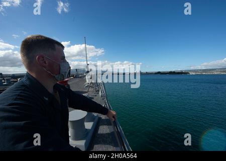 210104-N-FP334-1196 (Gen. 04, 2020) PEARL HARBOR Cryptologic Technician (Technical) 3rd Class Trevor Deibert, da Oil City, Penn., assegnato al cacciatorpediniere missilistico guidato di classe Arleigh Burke USS Ralph Johnson (DDG 114), guarda come la nave passa la USS Arizona Memorial a Pearl Harbor. Ralph Johnson è in corso nella terza area di attività Fleet. Foto Stock