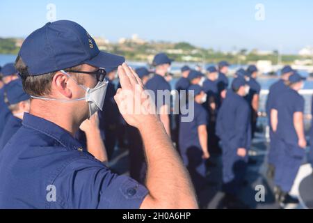 Guardia costiera degli Stati Uniti Lt. CMdR. Jason McCarthey saluta la bandiera degli Stati Uniti sul ponte di volo della pietra USCGC (WMSL 758) a Guantanamo Bay, Cuba, durante l'osservazione dei colori la mattina del 5 gennaio 2021. L'intero equipaggio della pietra si riunì sul ponte di volo per un incontro prima di partire da Guantánamo Bay. Foto Stock