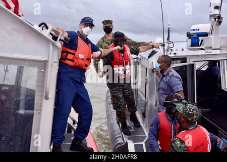 Guardia costiera degli Stati Uniti Lt. CMdR. Jason McCarthey, funzionario operativo della pietra USCGC (WMSL 758), urta i gomiti, come mitigazione COVID, con un membro della Guyana costa guardia al largo della costa della Guyana il 9 gennaio 2021, per celebrare l'esercizio congiunto. La Guardia Costiera degli Stati Uniti e la Guyana Coast Guard hanno completato il loro primo esercizio cooperativo di addestramento per combattere il traffico marittimo illecito dall'entrata in vigore di un accordo bilaterale tra i due il 18 settembre 2020. Foto Stock