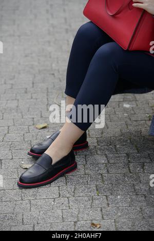 Concetto di moda femminile. Gambe donne in scarpe nere con linea rossa Foto Stock