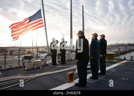 210111-N-QD512-1135 NORFOLK, Virginia (Gen. 11, 2020) i marinai salutano l'insegna nazionale durante i colori del mattino a bordo del cacciatorpediniere missilistico guidato di classe Arleigh-Burke USS Mitscher (DDG 57). Mitscher è attualmente in corso nell'Oceano Atlantico e svolge le proprie attività nell'ambito del Dwight D. Eisenhower Carrier Strike Group. Foto Stock