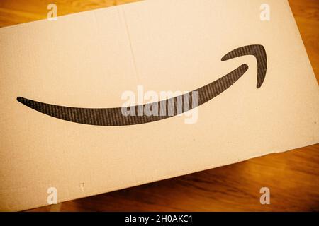 Pacco scatola di cartone Amazon prime sul pavimento in legno Foto Stock